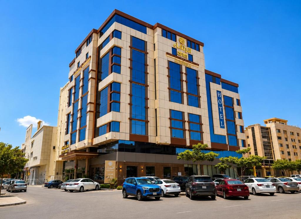 a building with cars parked in a parking lot at Al Ertiqaa Hotel in Jeddah