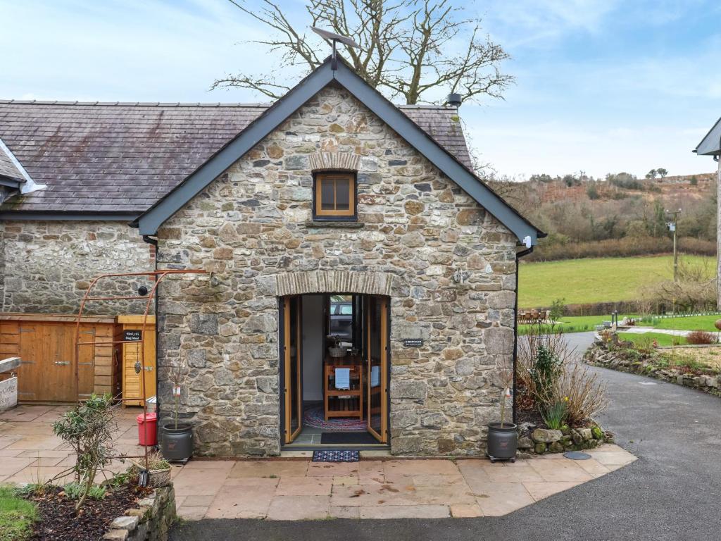 a stone house with a door in a driveway at Y-Beudy Bach - Uk51421 in Llandeilo