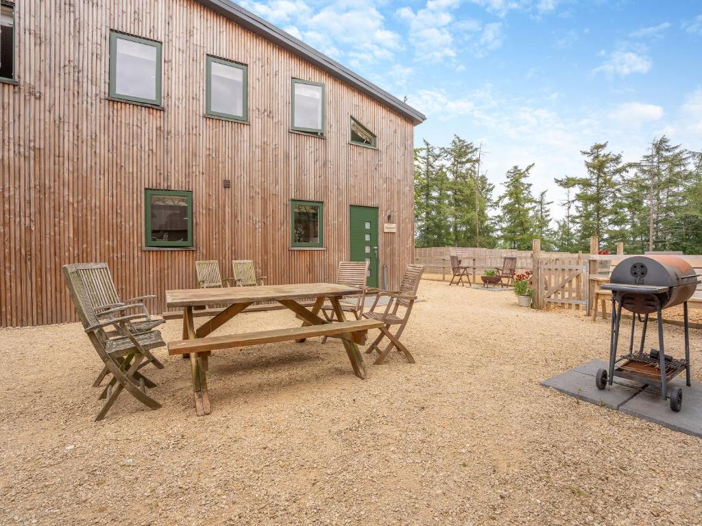 a picnic table and a grill in front of a building at Homewood - Uk36205 in Fordingbridge
