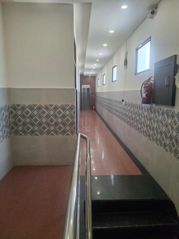 an empty hallway with escalators in a building at Hotel Park Blu in Pānīpat