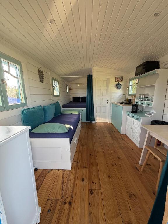 a living room with a couch in a tiny house at La Roulotte à Raven in Le Houga