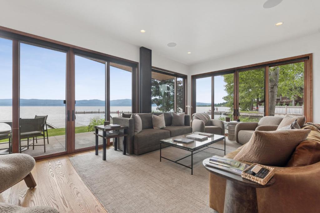 a living room with couches and a view of the water at Swan Lake House in Bigfork