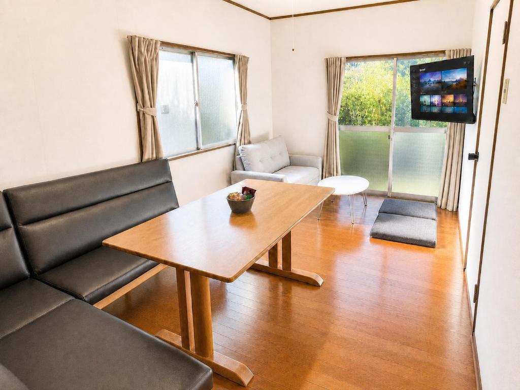 a living room with a table and a couch at 赤磐ベース in Akaiwa