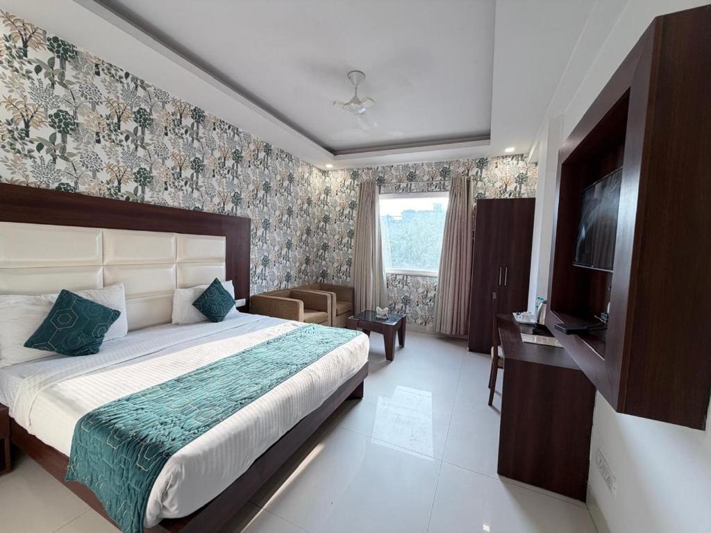 a bedroom with a large bed and a television at The Arch Premium - Delhi IGI Airport in New Delhi