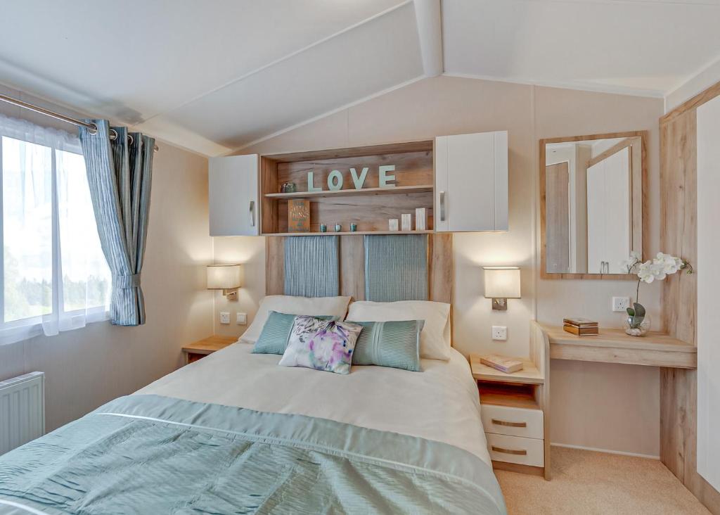 a bedroom with a large bed and a mirror at Unity Beach in Brean