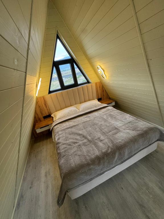 a bed in a small room with a window at SHAM A-frame in Bayetovka