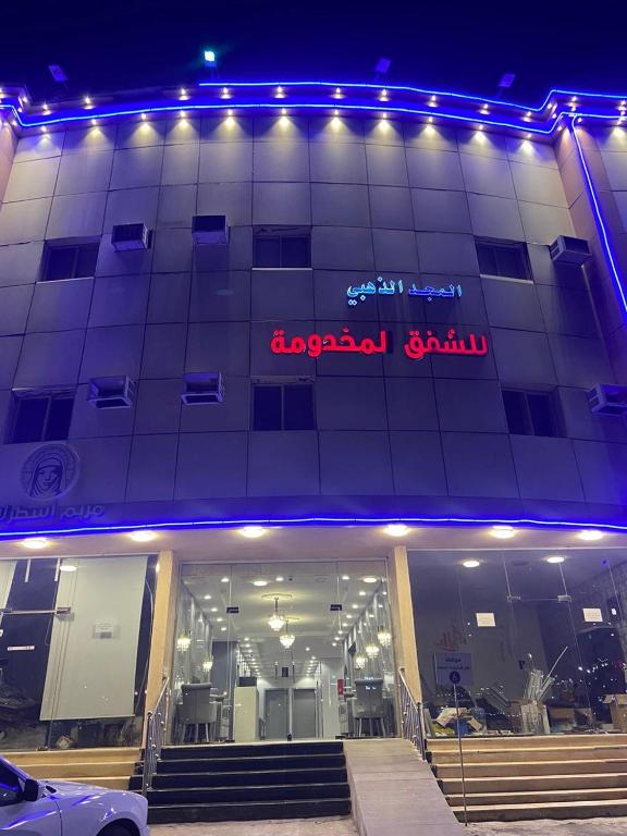 a building with a sign on the side of it at شقق المجد الذهبي للشقق المخدومة in Quai