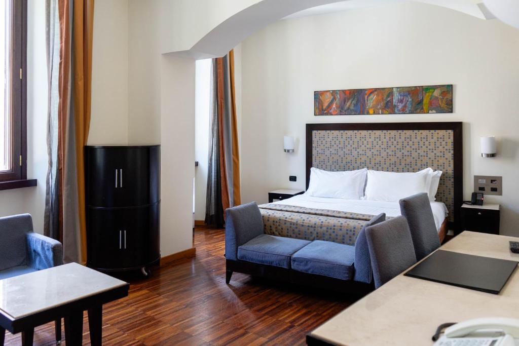a hotel room with a bed and a chair at Residenza Mecenate in Rome