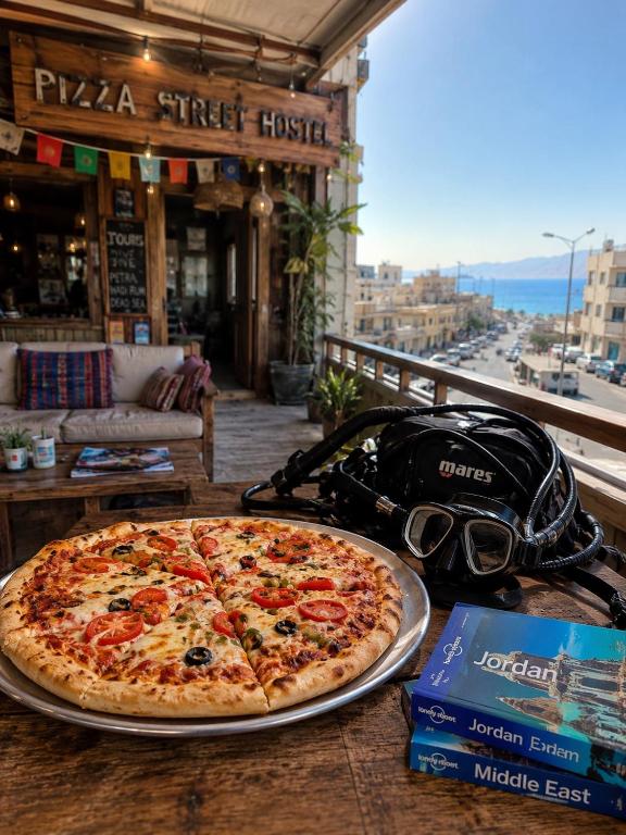 a pizza sitting on top of a table on a table at Pizza Street Hostel in Aqaba