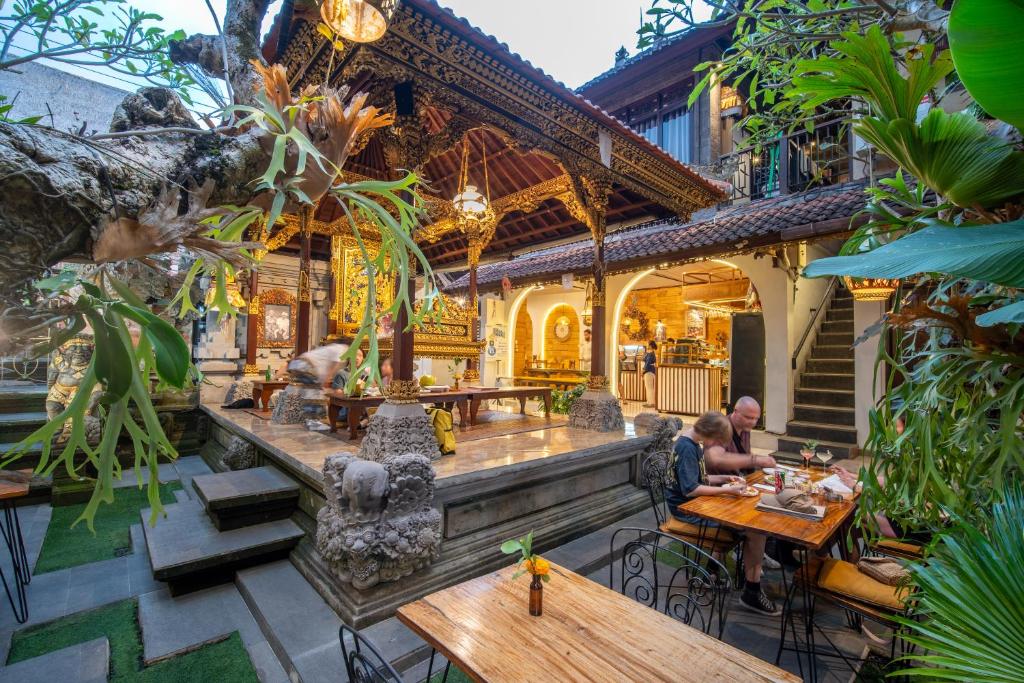 a restaurant with tables and people sitting at them at Ubud Heritage Stay by Dhananjaya Hospitality in Ubud