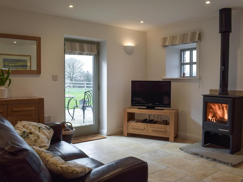 a living room with a couch and a fireplace at Five Barred Gate Barn in Inglewhite