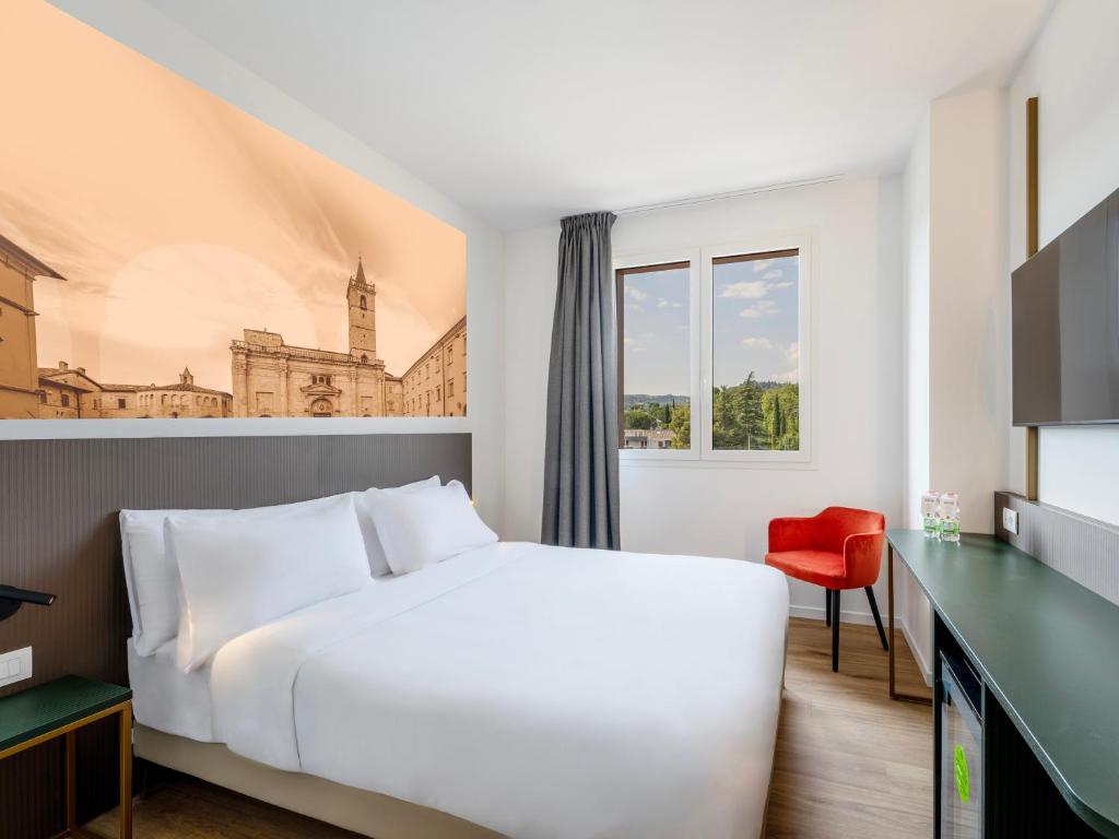 a hotel room with a white bed and a red chair at B&B HOTEL Ascoli Piceno in Ascoli Piceno