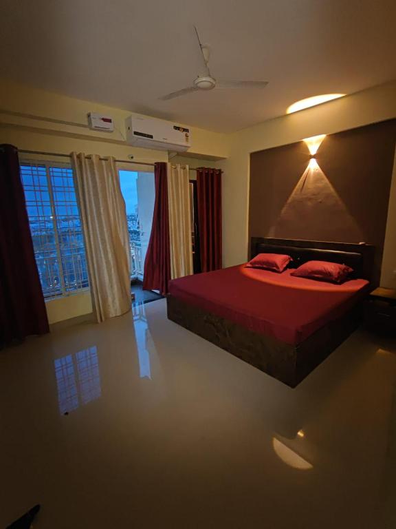 a bedroom with a bed with a red comforter at Aura Vista in Bhopal