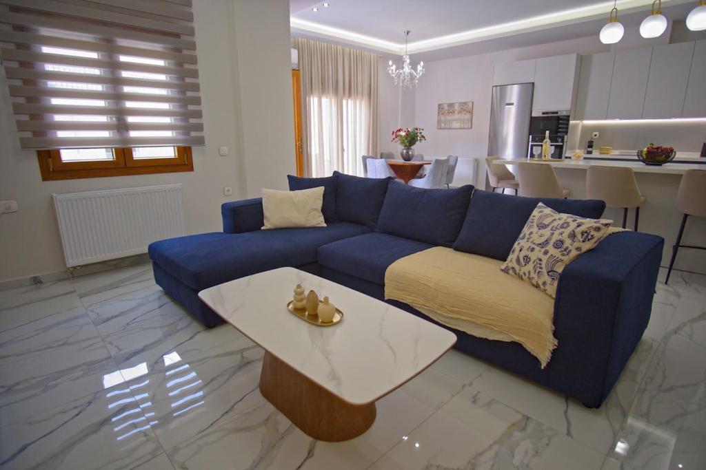 ein Wohnzimmer mit einem blauen Sofa und einem Tisch in der Unterkunft The Archanes Ruby in Archanes