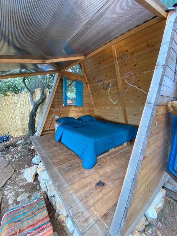 a bed in the inside of a wooden cabin at Snawbar glamping in ‘Ibrīn