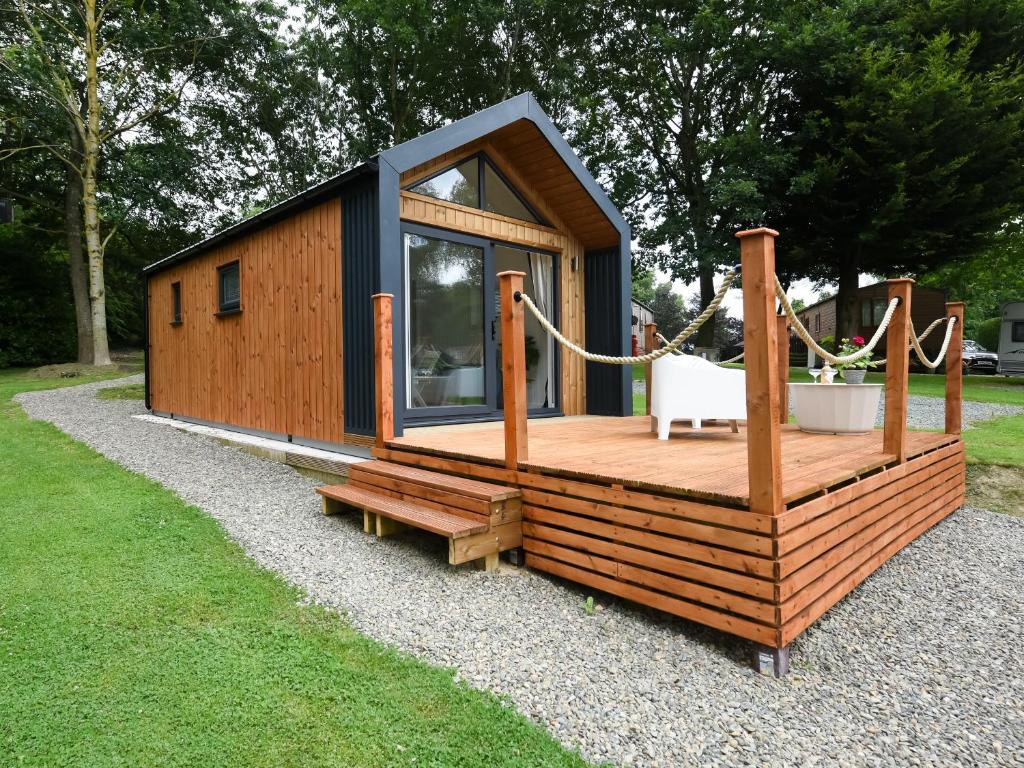 a small cabin with a deck and a chair at Mini Lodge - Uk47682 in Montgomery