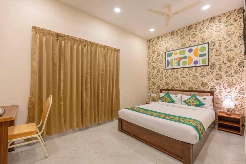 a bedroom with a bed and a table and a desk at Treebo Skanda Grande in Pondicherry