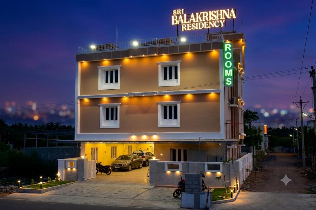 a building with a sign in front of it at night at Sri Balakrishna Residency in Thiruchendur