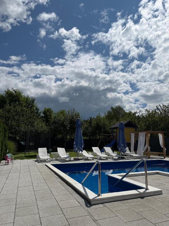 a swimming pool with lounge chairs and umbrellas at Luxury Apartments Sarajevo in Ilijaš