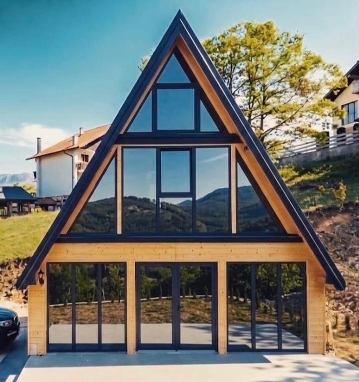 a house with a gambrel roof with glass windows at Stress Away in Zlatibor