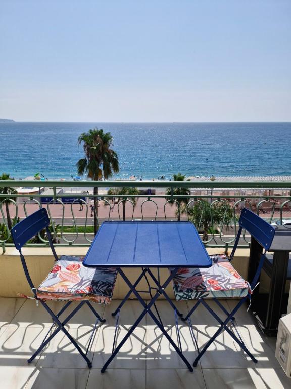 a blue table and chairs on a balcony with the ocean at Azur Pearl - Luxury Sea View Apartement - La plage à vos pieds in Nice