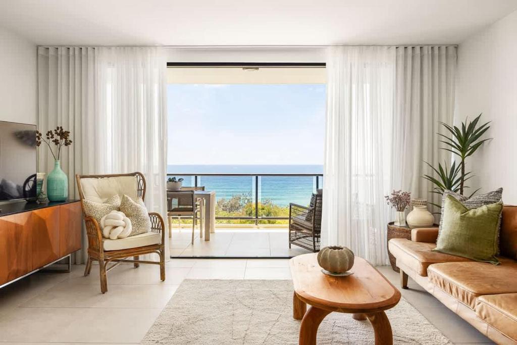 a living room with a view of the ocean at Postcard on Sunrise in Sunrise Beach