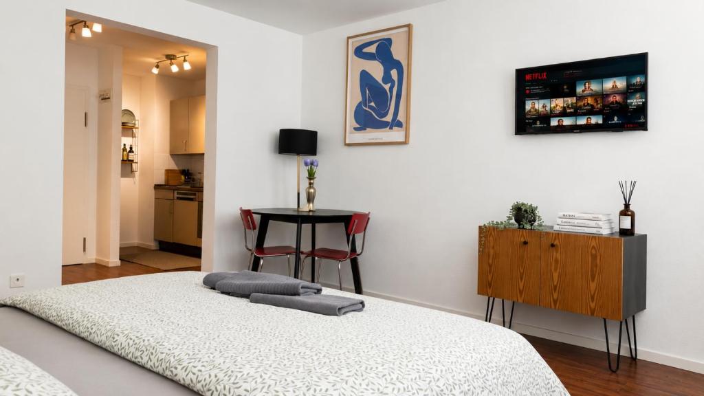 a bedroom with a bed and a table with a chair at Central Studio Apartment with free BaselCard - Magritte in Basel