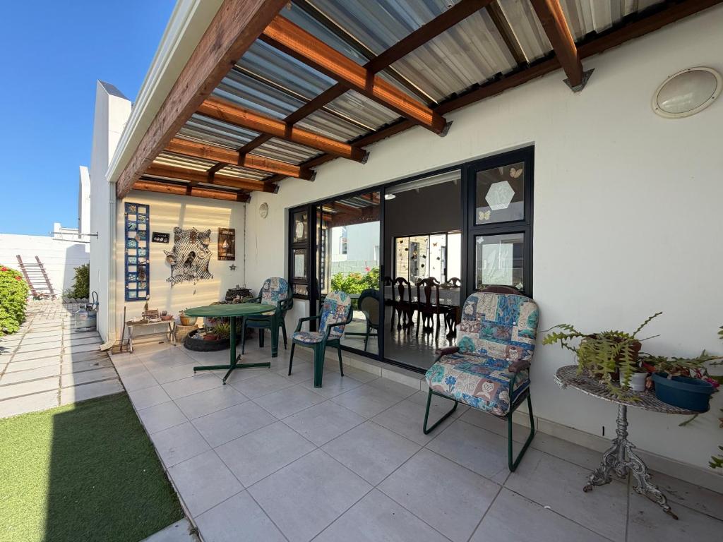 a patio with a table and chairs and a ceiling at Sunset Sands in St. Helena Bay