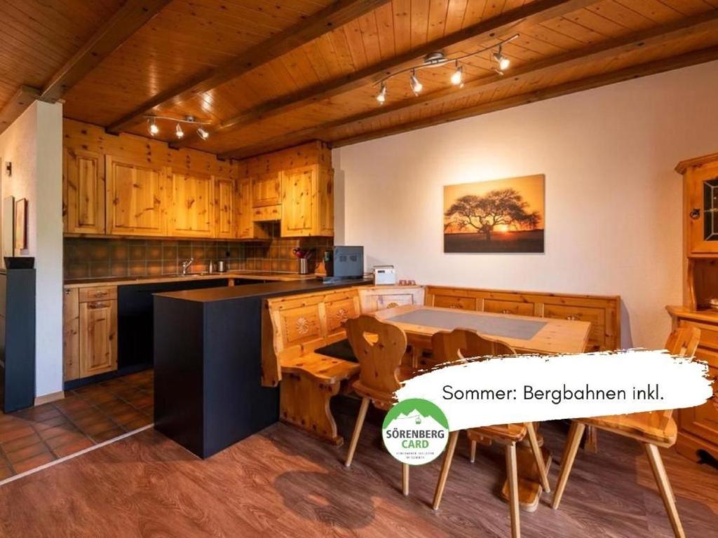 a kitchen with wooden cabinets and a table with chairs at Apartment Wohnung Wettstein by Interhome in Sörenberg