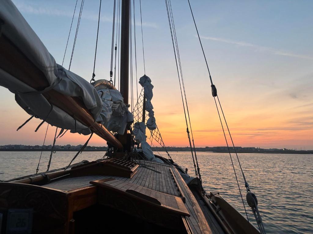 a boat in the water with a sunset in the background at Argovia Dutch Barge in Brightlingsea