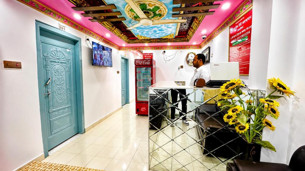 a man sitting at a desk in a room with a laptop at Hotel New Kalabagan in Dhaka