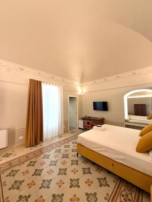 a hotel room with a bed and a mirror at Bellavitarooms-Fiore di Maggio Luxury Suites in Matera