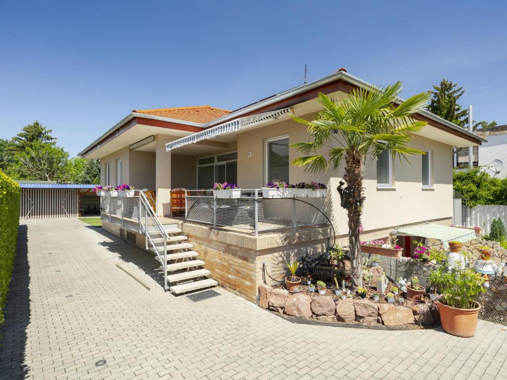 a house with a palm tree in front of it at Apartment Beige by Interhome in Balatonszemes