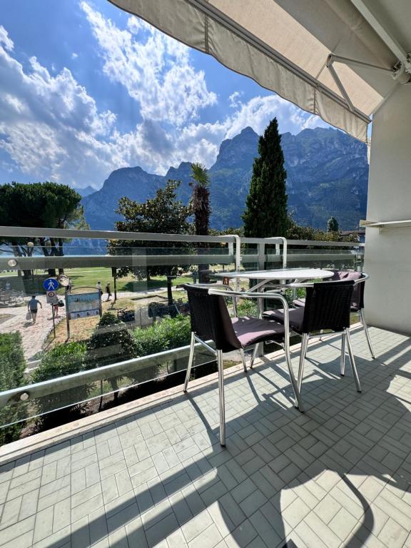 a table and chairs on a balcony with a view of mountains at Lago Blu in Riva del Garda