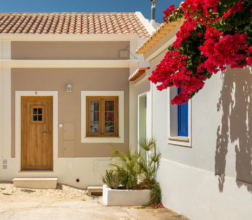 a house with red flowers on the side of it at Casinha do Beco in Lagos