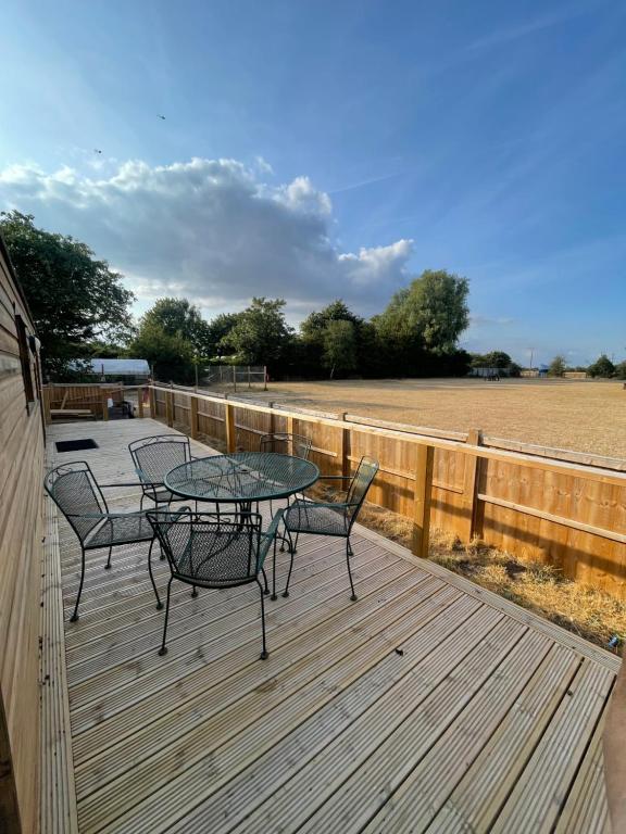a patio with a table and chairs on a wooden deck at Gunthorpe Mobile Home in East Bridgford