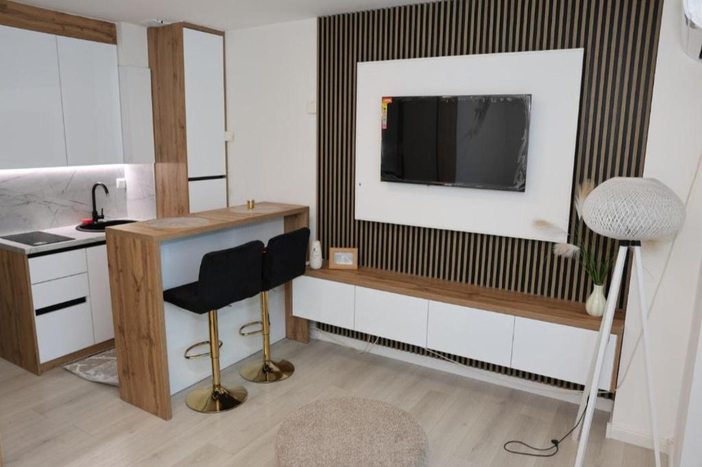 ein Zimmer mit einem Schreibtisch, einem Fernseher und einem Stuhl in der Unterkunft Square Studio Brcko in Brčko