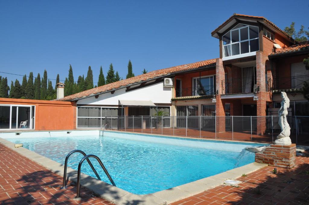 a large swimming pool in front of a house at Domaine de Hurlevent in Montgaillard-Lauragais