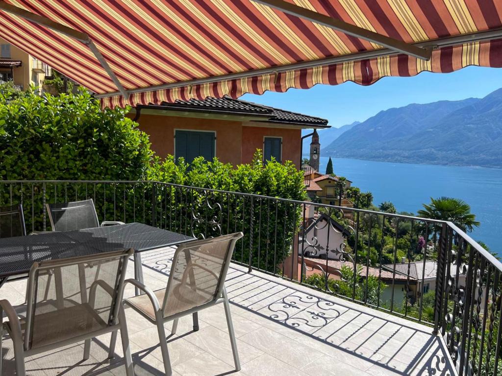 a balcony with a table and chairs and a view of the water at Molino Vecchio in Ronco sopra Ascona