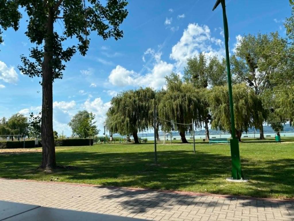 a park with trees and a pole in the grass at Balat-ON Apartman in Balatonberény