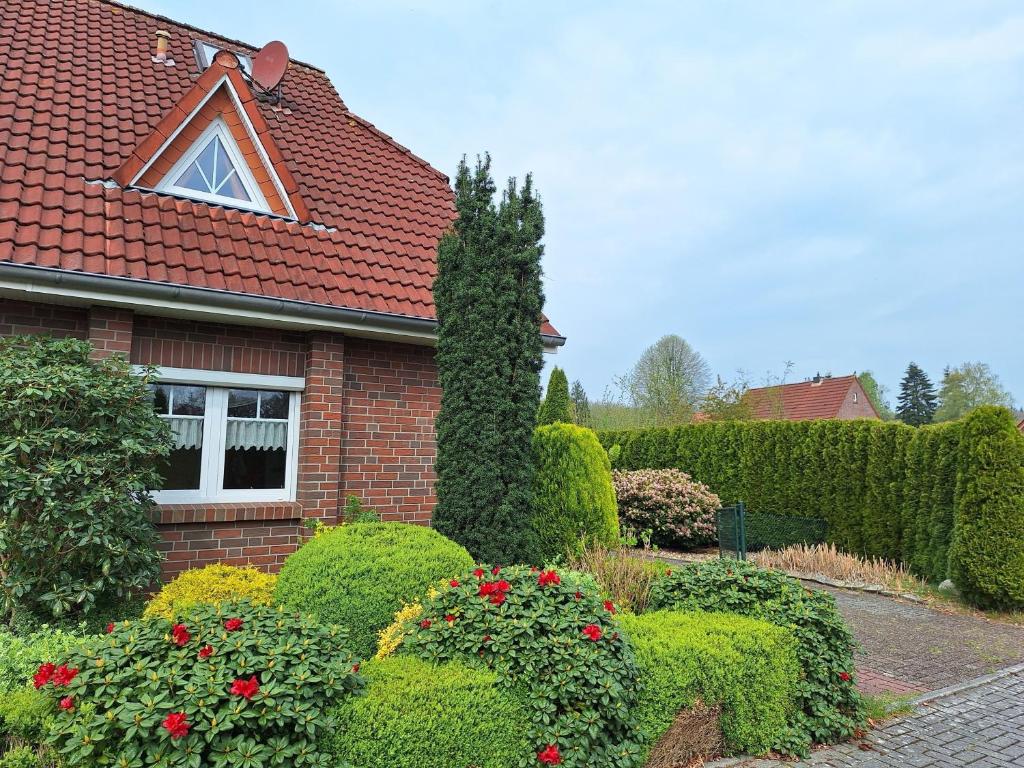 a red brick house with bushes and flowers at Mövennest in Berumbur