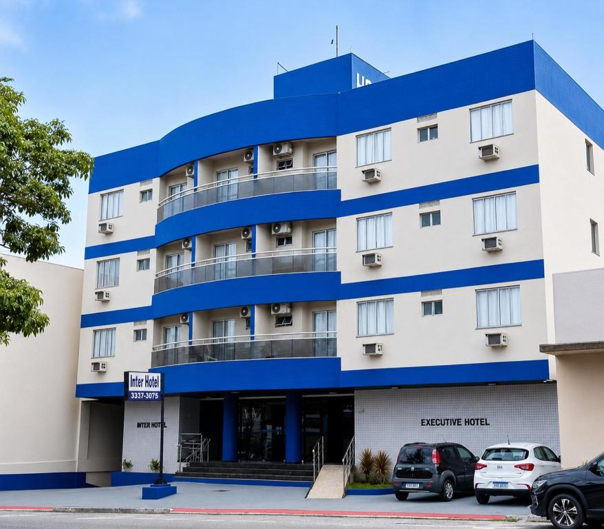 a hotel building with cars parked in front of it at Inter Hotel in Vitória