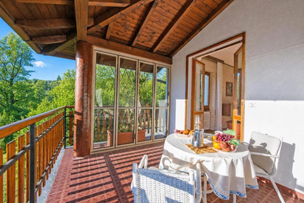 a porch with a table and chairs on a balcony at Villa La Verbanina Private Garden - Happy Rentals in Ghiffa