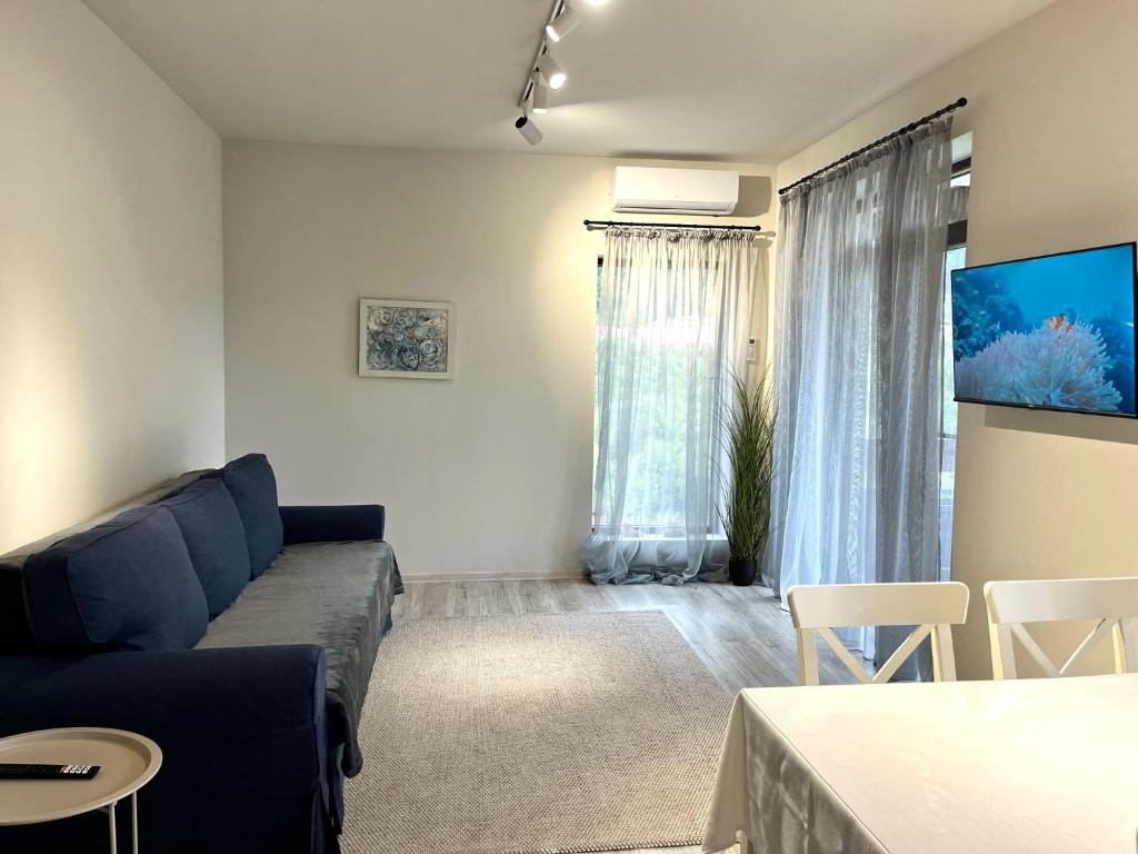 a living room with a blue couch and a table at Mountain Stream Serenity - AC and Free Parking in Buşteni