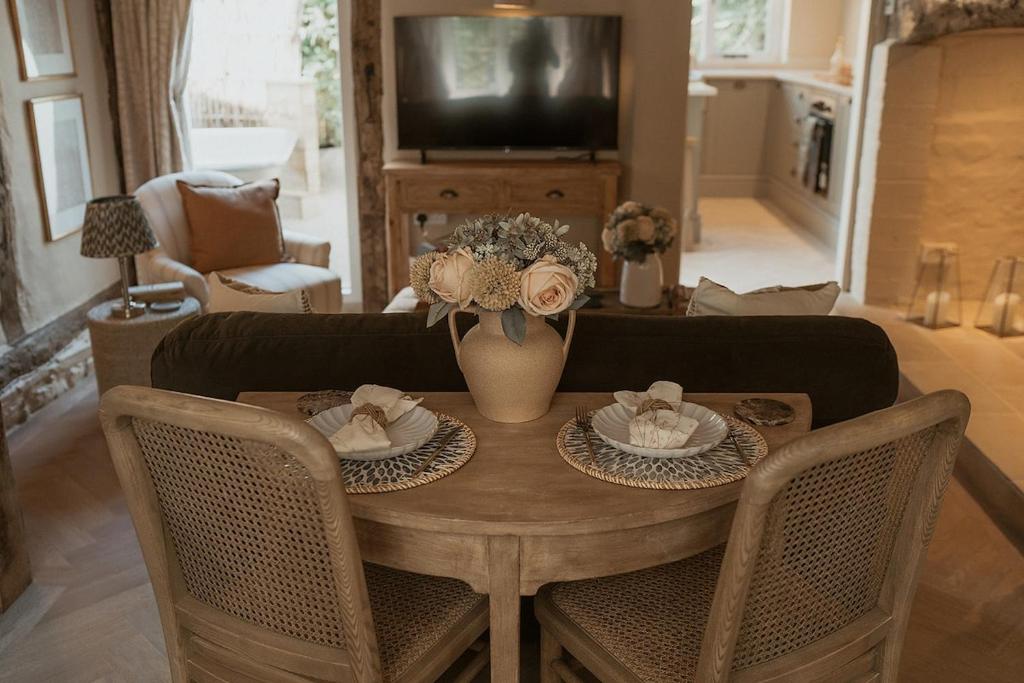 a living room with a table and a couch at Hathaway Hamlet in Stratford-upon-Avon