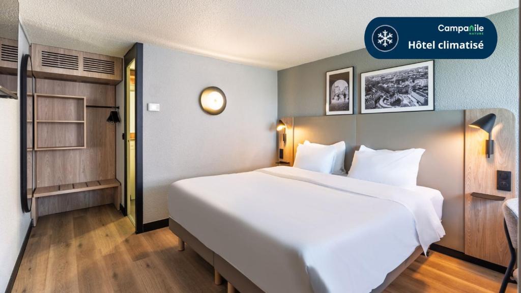 a large white bed in a hotel room at Campanile NATURE - Lille Wasquehal in Wasquehal