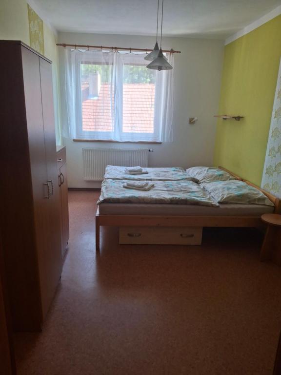 a bedroom with a bed in a room with a window at penzion BON TRE in Třeboň