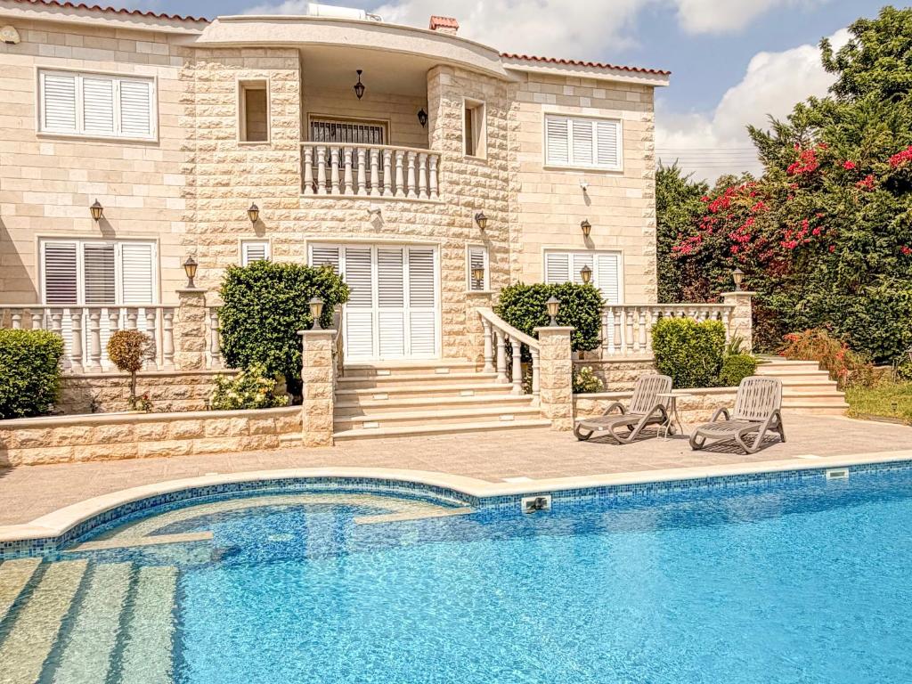 a house with a swimming pool in front of a house at Luxury Villa Aurelia in Peyia