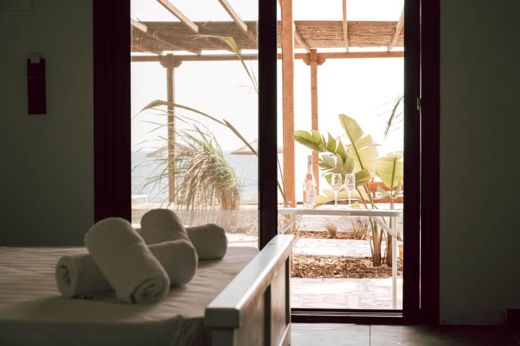 a bedroom with a bed with a view of the beach at Burano Camping Beach-Bar in Néa Thésis
