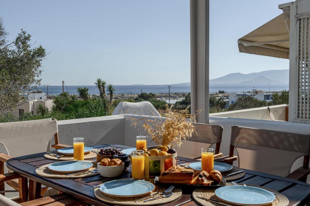 a table with food on a balcony with a view of the ocean at Villa Irina in Agios Prokopios